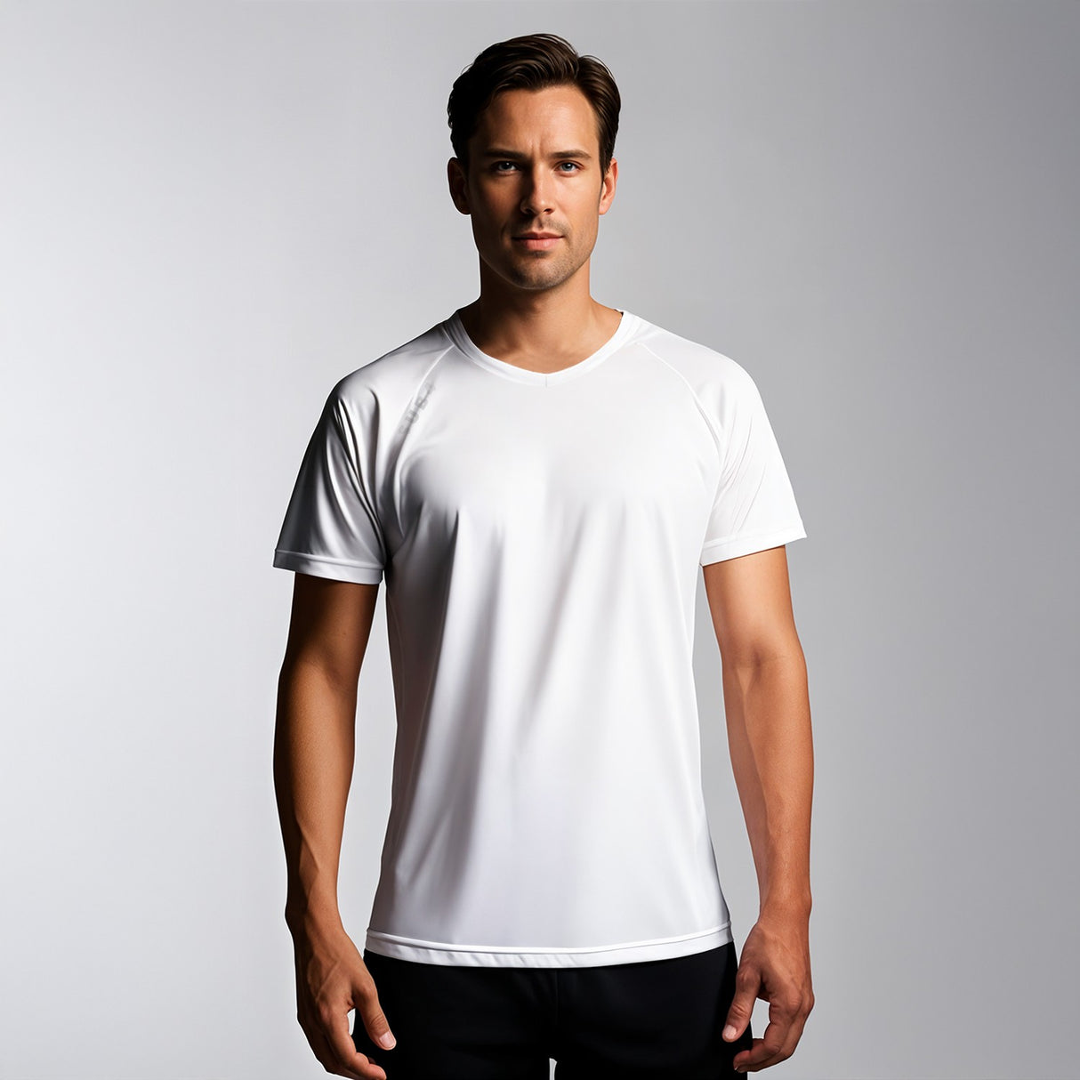 Man wearing a plain white t-shirt against a gray background