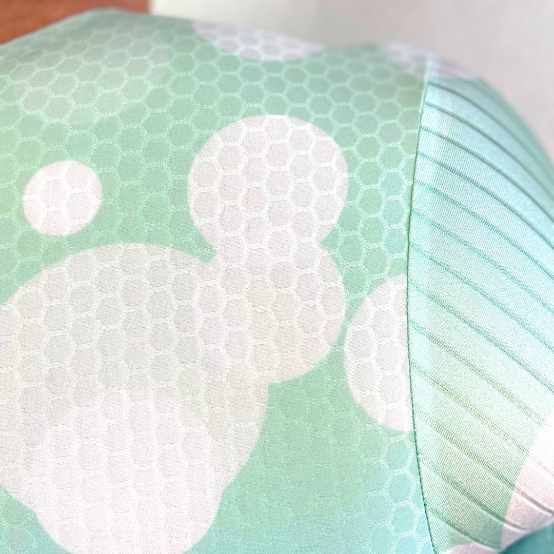 Close-up of a fabric with white cloud patterns on a light green background