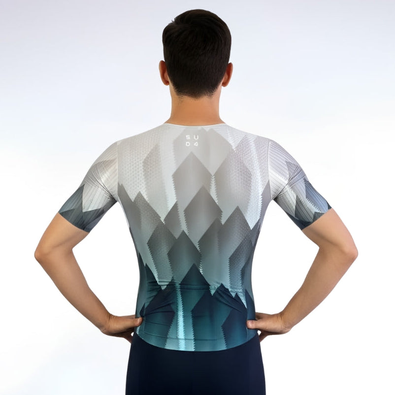 Person wearing a geometric patterned cycling jersey and shorts on a white background