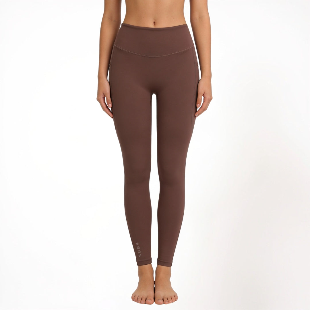 Brown athletic yoga leggings worn by a person on a white background