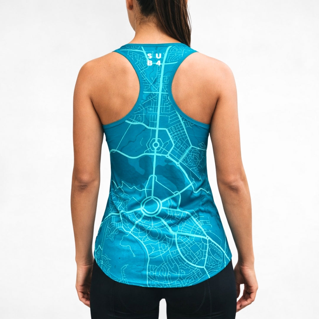 Person wearing a blue tank top racerback singlet with a Canberra map design on a plain background