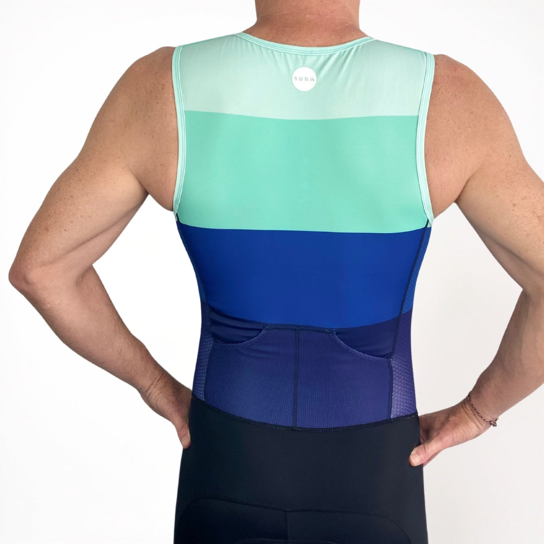 Person wearing a two-tone Triathlon suit with green and blue design on a white background