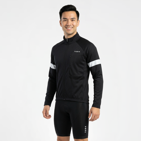 Person wearing black cycling jersey and shorts with white reflective accents on a light gray background