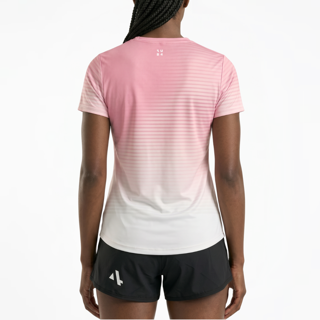 Back view of woman wearing a pink and white gradient running t-shirt and black running shorts on a white background