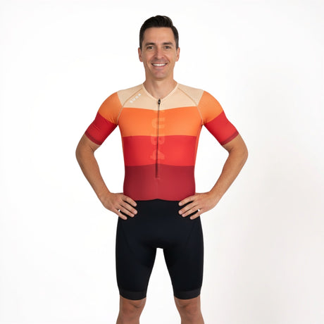Man wearing a colourful triathlon outfit on a white background