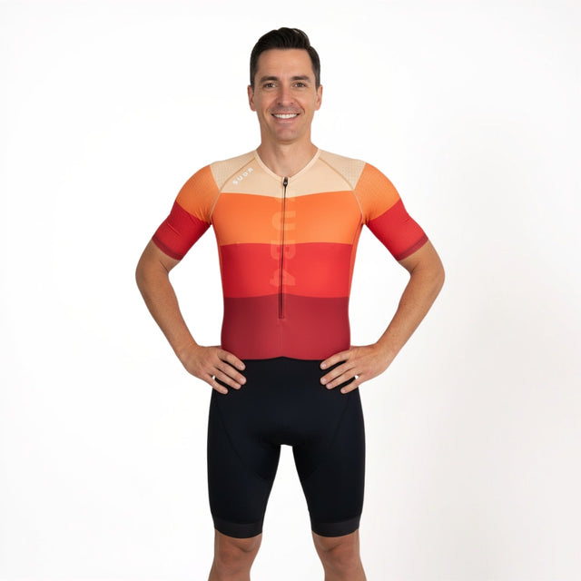 Man wearing a colourful triathlon outfit on a white background