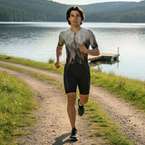 Person running on a path by a lake with mountains in the background