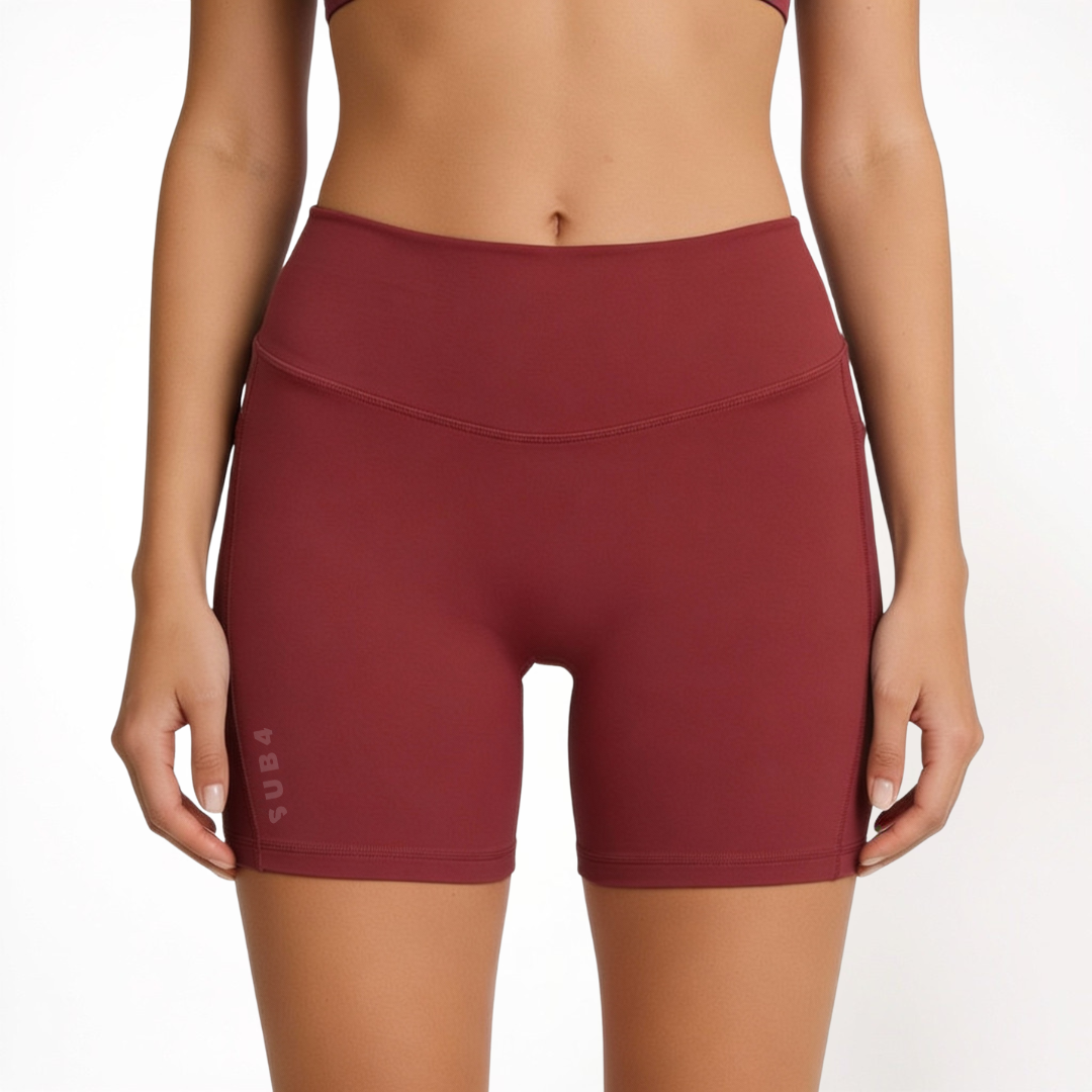 Maroon red athletic shorts worn by a person on a white background