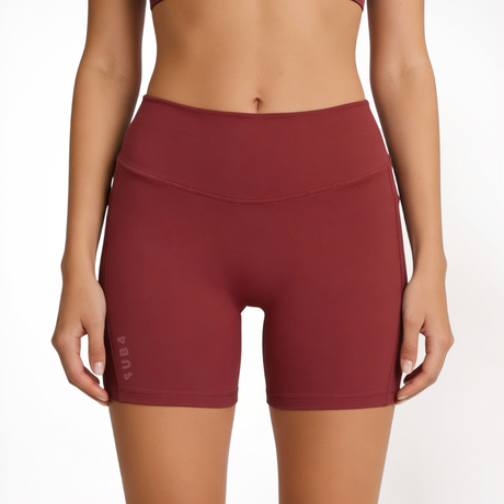 Maroon red athletic shorts worn by a person on a white background