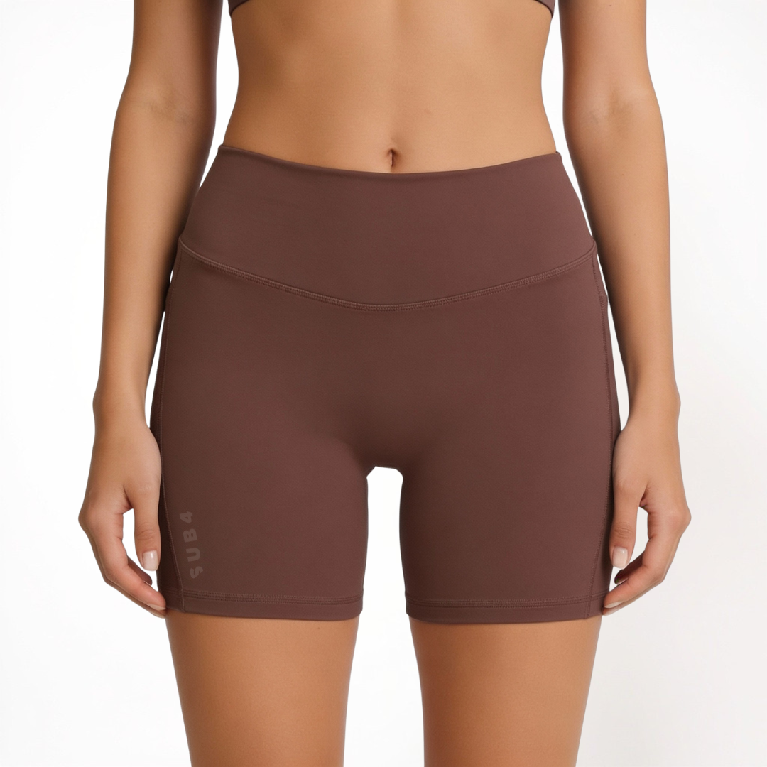 Brown athletic shorts worn by a person on a white background