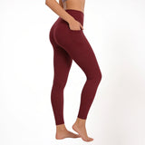 Red maroon athletic gym yoga leggings worn by a person on a white background