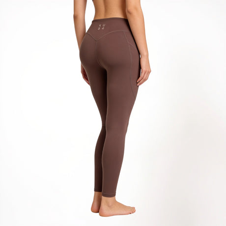 Brown athletic gym yoga leggings worn by a person on a white background