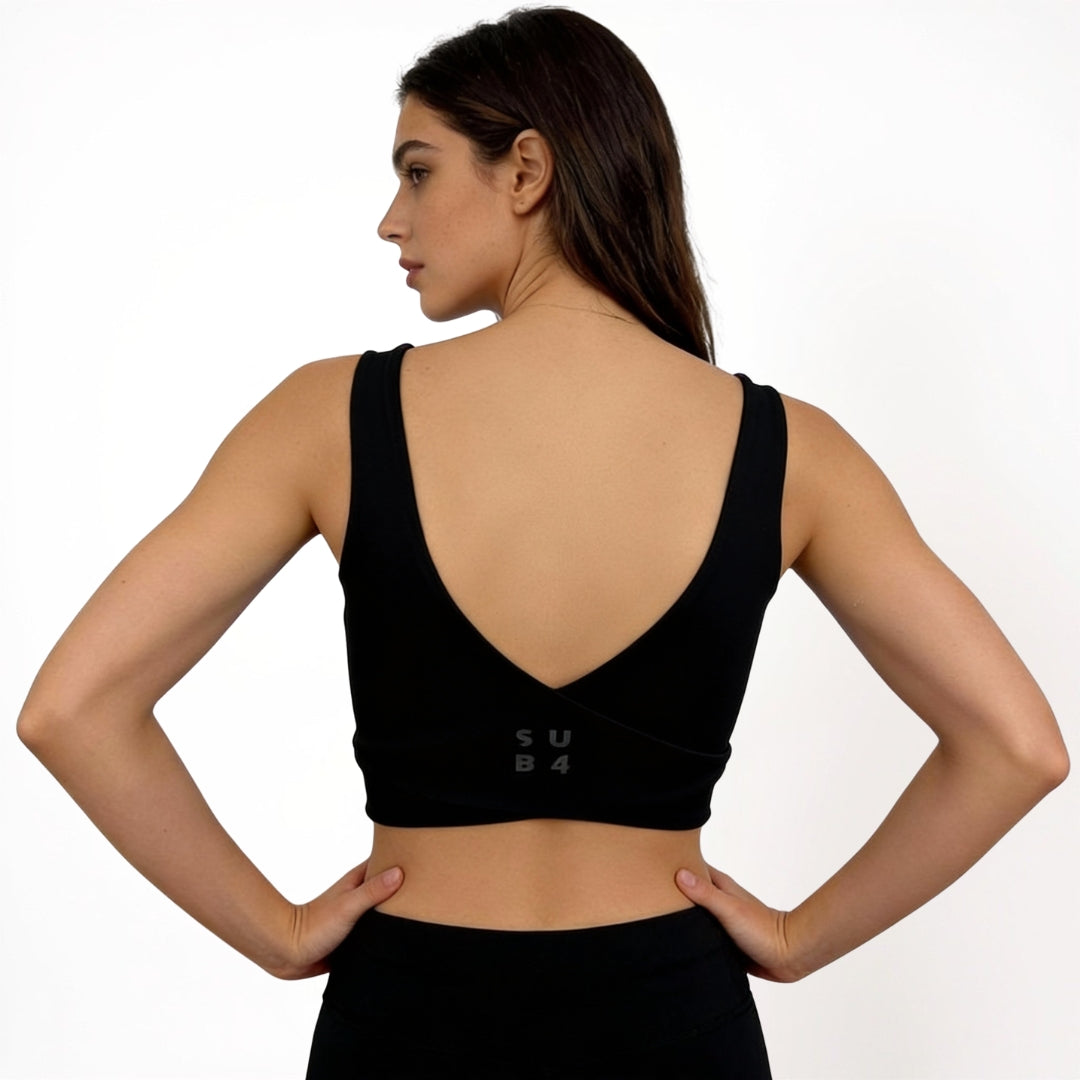 Woman wearing a black sports bra with 'SUB4' branding on a white background