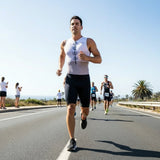 Man running on a road with a clear sky and palm trees in the background