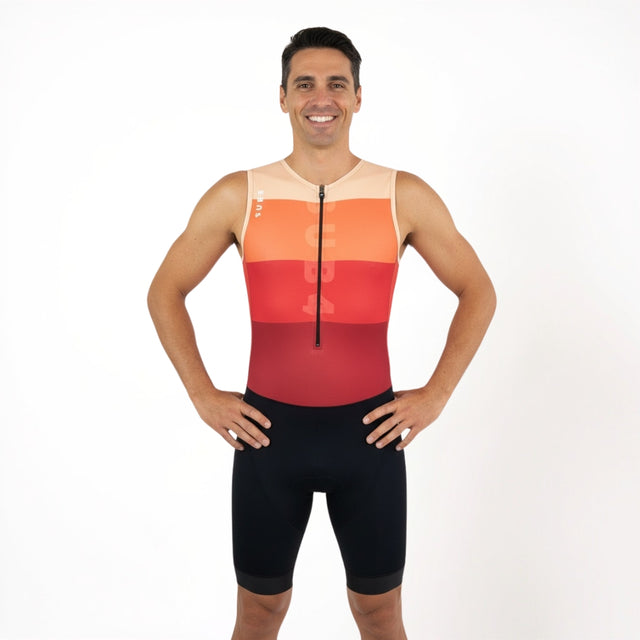Man wearing a red, orange, and black triathlon suit on a white background