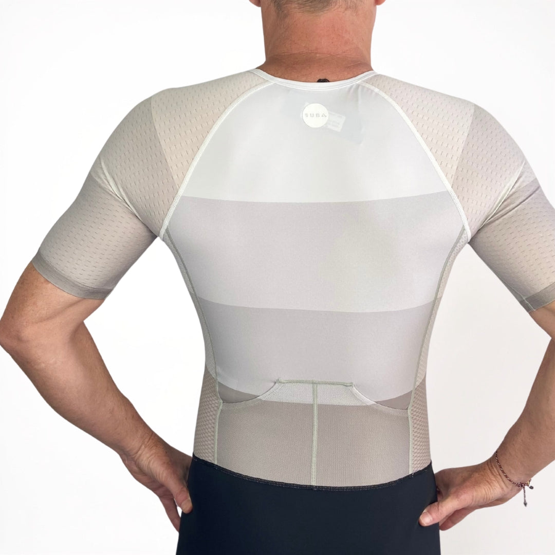 Person wearing a white Triathlon suit with mesh panels on a plain background